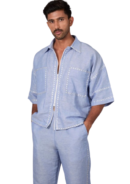 Man wearing a light blue short-sleeved shirt and matching pants with white stitching detail.
